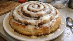 Giant cinnamon roll cake with vanilla icing – a centrepiece bake for brunch